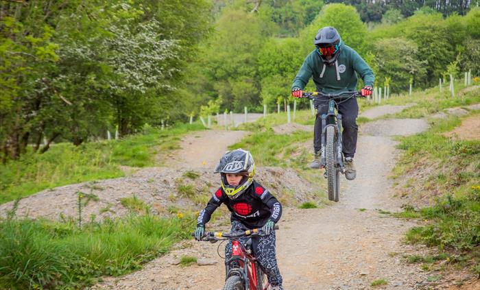 A young rider and her dad riding one of the blue graded trails
